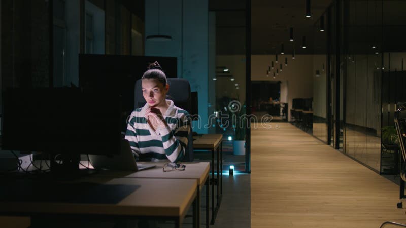 Empresaria mujer de negocios trabajando hasta tarde en la oficina usando una laptop mientras se siente cansada y quemada. Lectura almacen de metraje de vídeo