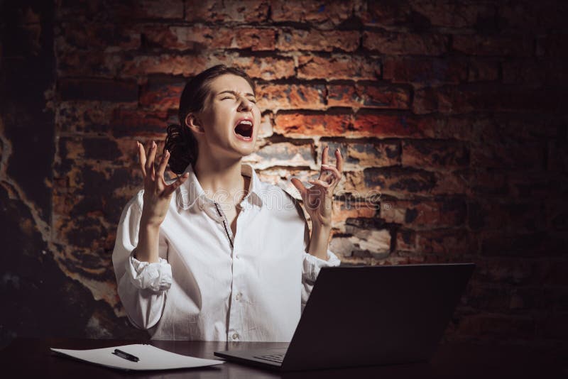 Empresaria mujer desesperada que trabaja con una pared de ladrillo para laptop fotos de archivo