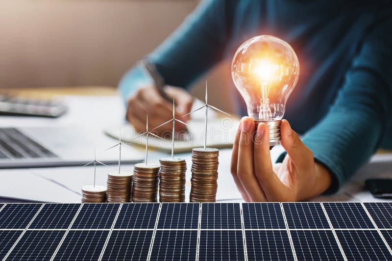 Empresaria portando bombilla de luz con turbina en monedas y panel solar. contabilidad de ahorro de energÃ­a y finanzas