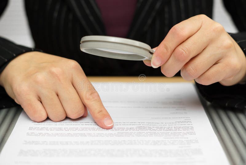 Businesswoman looking through a magnifying glass to contract. Businesswoman looking through a magnifying glass to contract