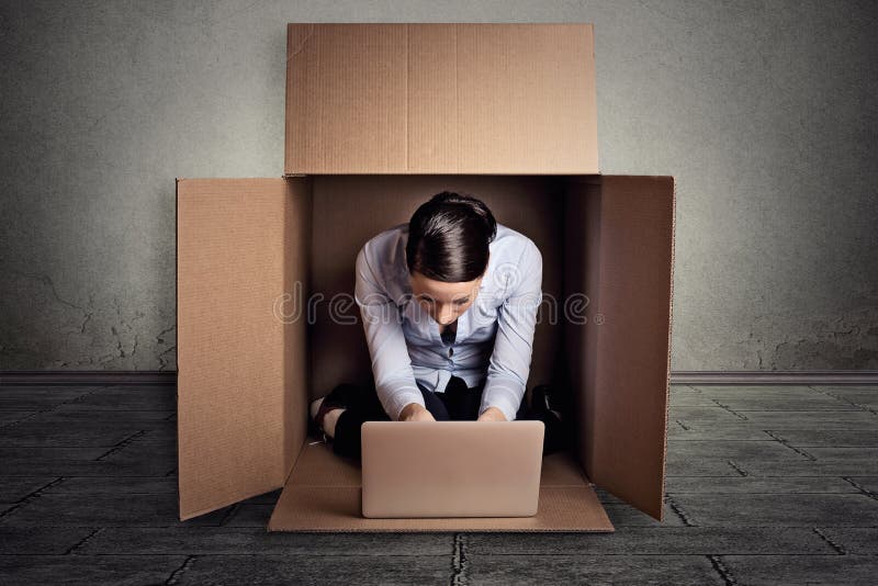 Empresaria que se sienta en la caja del cartón que trabaja en el ordenador portátil imagenes de archivo Empresaria que se sienta en la caja del cartón que trabaja en el ordenador portátil imagenes de archivo