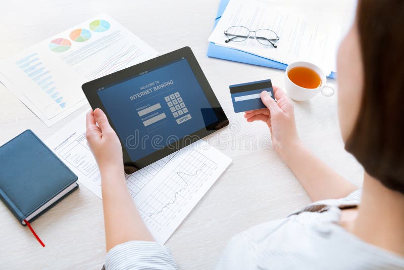 Empresaria que usa una tarjeta de crédito para las actividades bancarias en línea de Internet foto de archivo libre de regalías Empresaria que usa una tarjeta de crédito para las actividades bancarias en línea de Internet foto de archivo libre de regalías