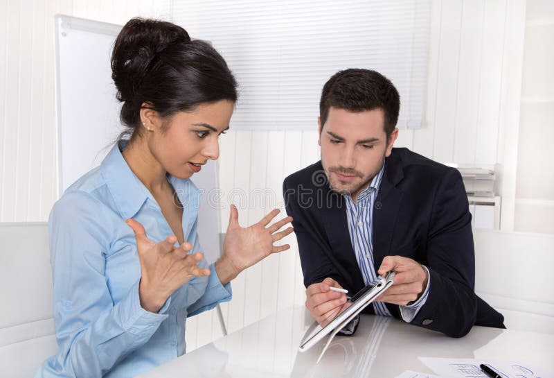 Empresaria sorprendente en azul con su jefe que mira el SCR de la tableta imagenes de archivo Empresaria sorprendente en azul con su jefe que mira el SCR de la tableta imagenes de archivo