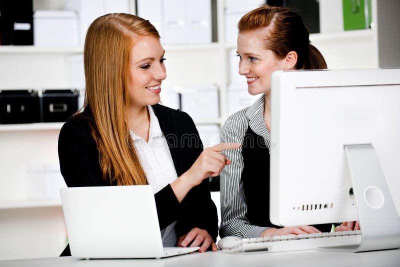 Empresarias con la computadora portátil y el ordenador imágenes de archivo libres de regalías Empresarias con la computadora portátil y el ordenador imágenes de archivo libres de regalías