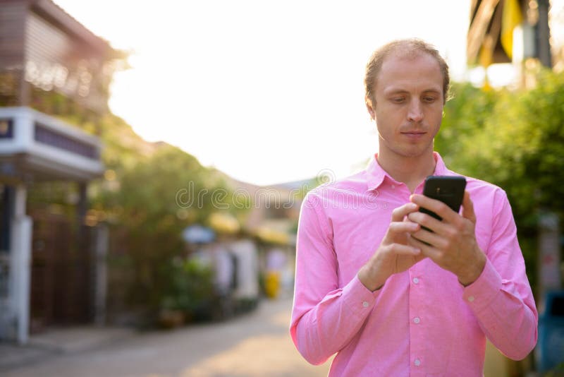 Empresario de pelo rubio con teléfono en la calle al aire libre imagen de archivo