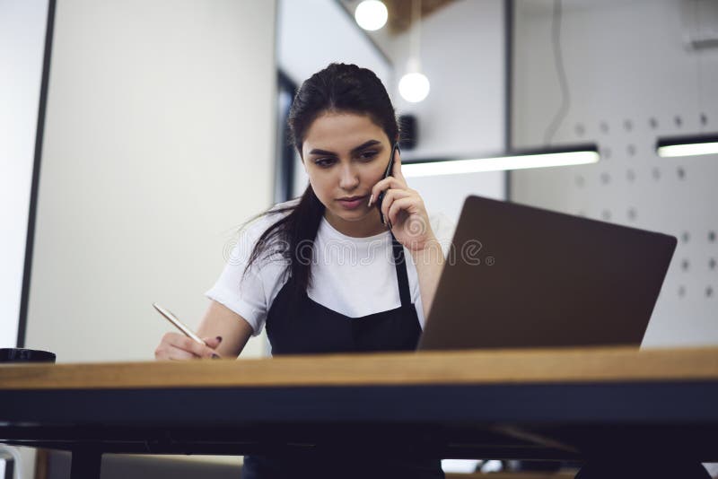 Empresario de sexo femenino joven de la cafetería que trabaja con los documentos de papel fotografía de archivo libre de regalías Empresario de sexo femenino joven de la cafetería que trabaja con los documentos de papel fotografía de archivo libre de regalías