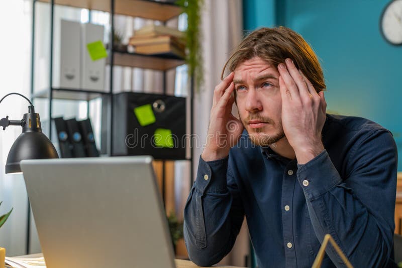 Empresario enfermo y cansado que sufre de problemas de dolor de cabeza tensión y migraña estrés en la oficina del hogar foto de archivo