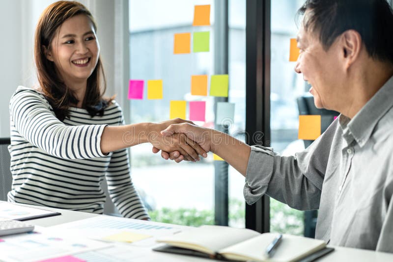 Empresario estrechando la mano con una mujer de negocios después de discutir un buen acuerdo de contrato comercial y un nuevo proy imagen de archivo