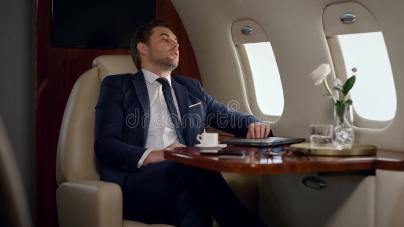 Empresario europeo termina trabajo cerrando laptop. asiento de avión cansado de hombre inclinado