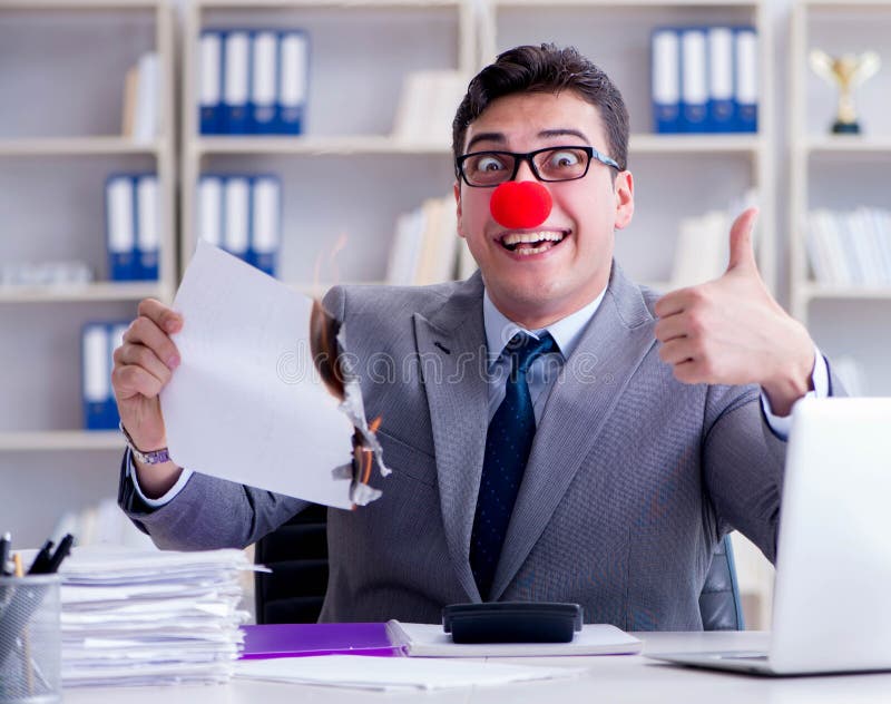 Empresario payaso quemando papeles en la oficina imágenes de archivo libres de regalías