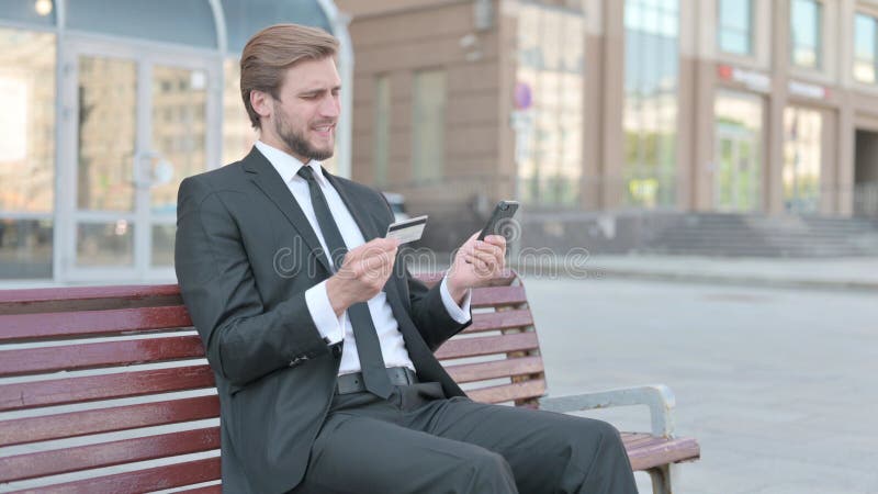Empresario reaccionando a un problema de pago en línea a través de una sesión de smartphone al aire libre imagenes de archivo