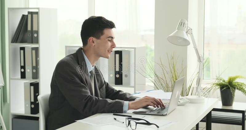 Empresario riéndose en el trabajo en la oficina almacen de video
