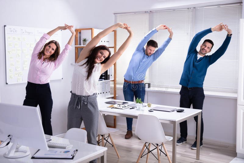 Empresarios haciendo ejercicio detrás de escritorio