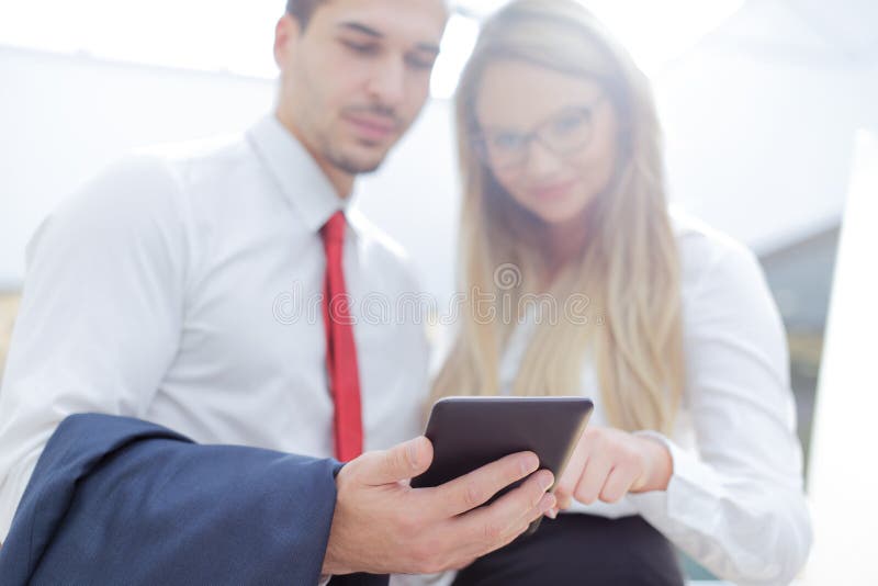 Empresarios jovenes que usan la tableta en centro de negocios imágenes de archivo libres de regalías Empresarios jovenes que usan la tableta en centro de negocios imágenes de archivo libres de regalías