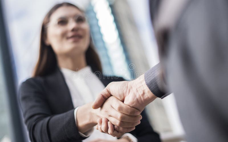 Empresarios que hacen que la mano sacude en la ciudad imagen de archivo Empresarios que hacen que la mano sacude en la ciudad imagen de archivo