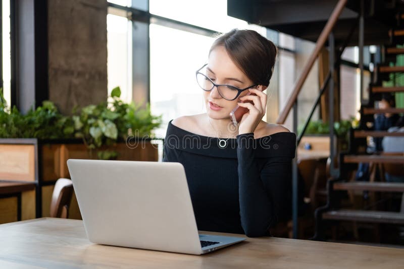Empresária que trabalha em laptop no café imagens de stock Empresária que trabalha em laptop no café imagens de stock