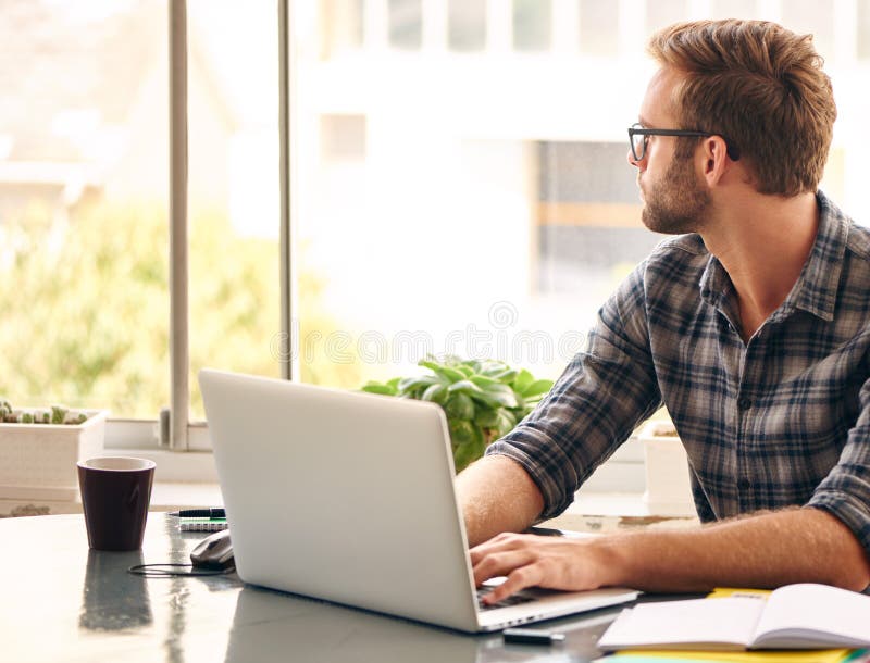 Empresário novo que olha para fora a janela no pensamento foto de stock Empresário novo que olha para fora a janela no pensamento foto de stock