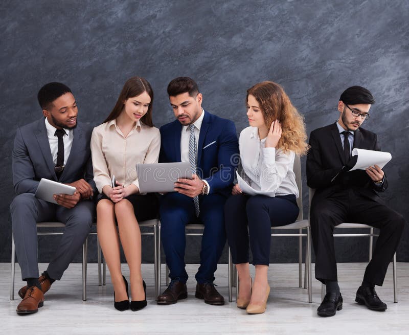 Empresários novos multiculturais que usam portáteis e smartphones fotos de stock Empresários novos multiculturais que usam portáteis e smartphones fotos de stock