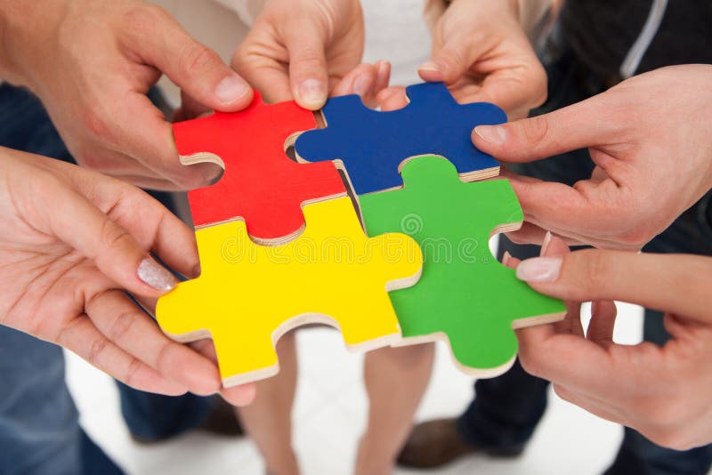 Empresários a encaixar peças de puzzle imagens de stock