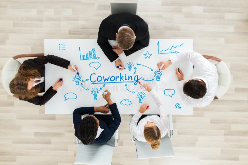 Empresários que sentam-se no espaço de CoWorking imagens de stock royalty free Empresários que sentam-se no espaço de CoWorking imagens de stock royalty free