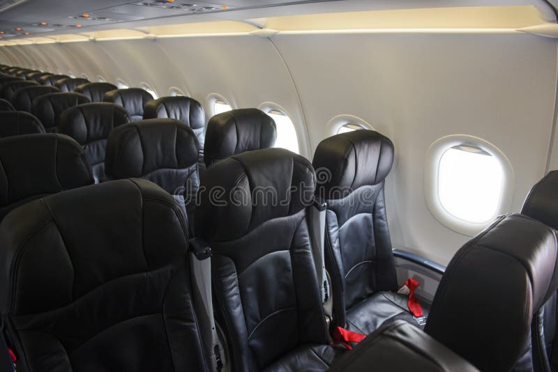 Empty aircraft black leather economy class seats and windows stock image Empty aircraft black leather economy class seats and windows stock image