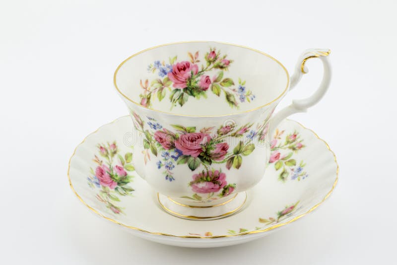 Empty antique cup and saucer with rose decoration isolated on white - English tea