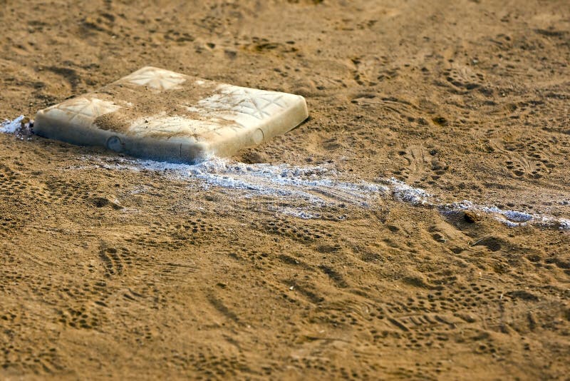 Empty base on chalked baseball field, symbol of accomplishment. Empty base on chalked baseball field, symbol of accomplishment