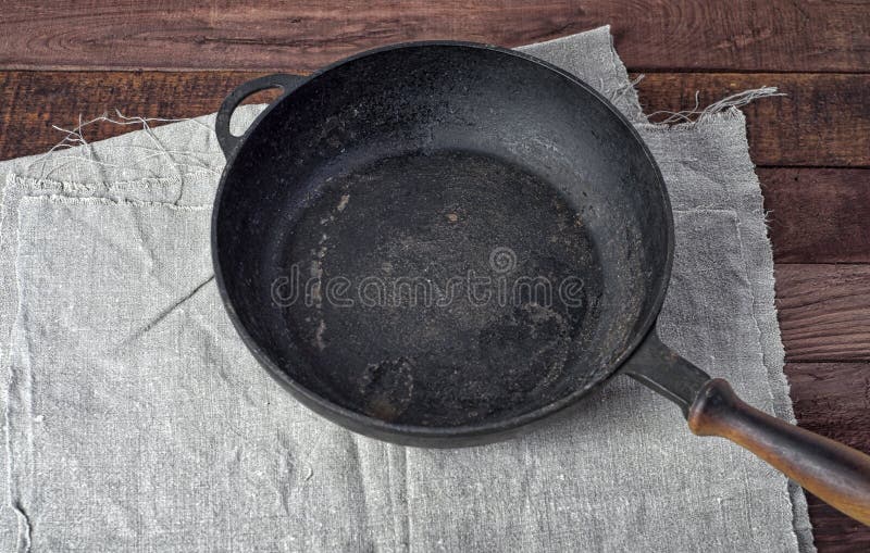 Empty black cast iron pan on textile napkin