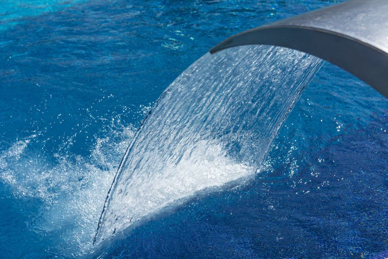 Empty Blue Water Pool with a Waterfall Stream in Action. Relaxation