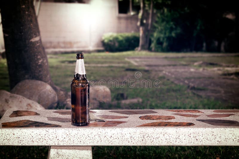 Empty Bottle of Beer on a Park Bench in Public. Stock Image Image of