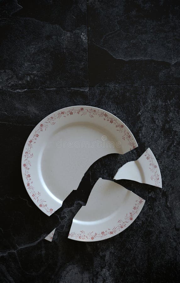 Empty Cracked Broken Plate on Black Tiled Marble Background Floor or