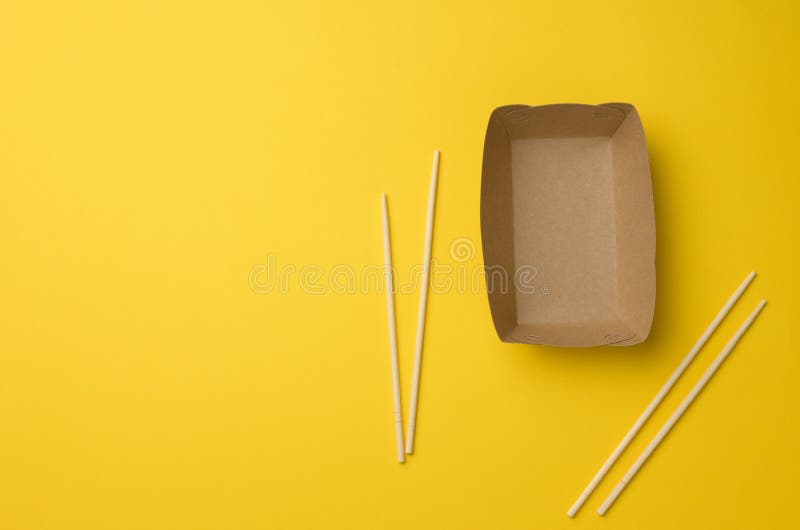 Empty Brown Paper Plate and Wooden Chopsticks on a Yellow Background