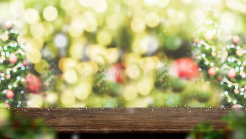 Empty dark brown wood table top with abstract blur christmas tree red decor ball and snow fall background with