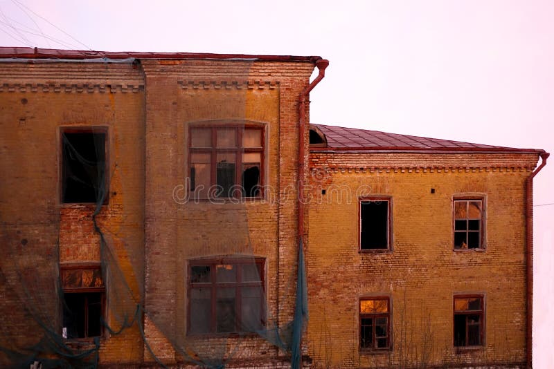 Empty destroyed building with broken windows. Pink sky Sunset. Photo in red colors. The oppressive atmosphere of destruction. stock photos Empty destroyed building with broken windows. Pink sky Sunset. Photo in red colors. The oppressive atmosphere of destruction. stock photos