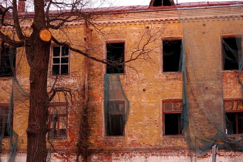 Empty destroyed building with broken windows. Pink sky Sunset. Photo in red colors. The oppressive atmosphere of destruction. stock photography Empty destroyed building with broken windows. Pink sky Sunset. Photo in red colors. The oppressive atmosphere of destruction. stock photography
