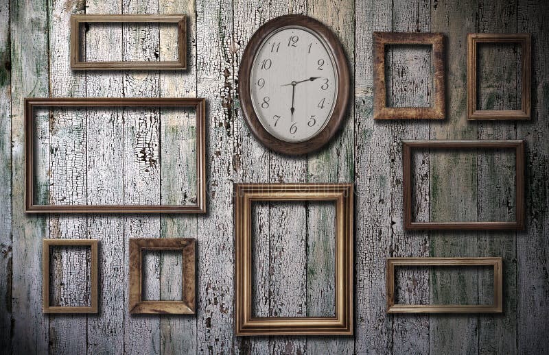 Empty frames and watch on wooden wall