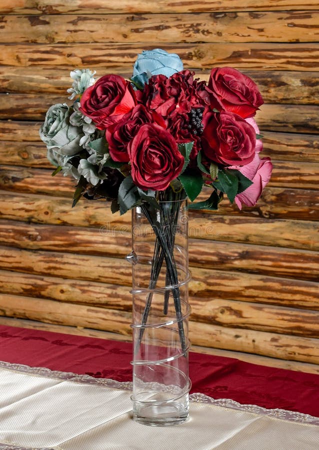 An empty glass vase with artificial flowers