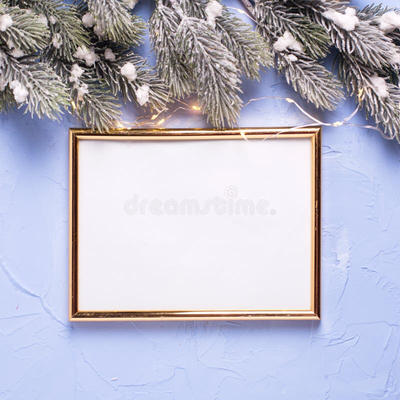 Empty golden frame and Christmas decorations on blue textured b