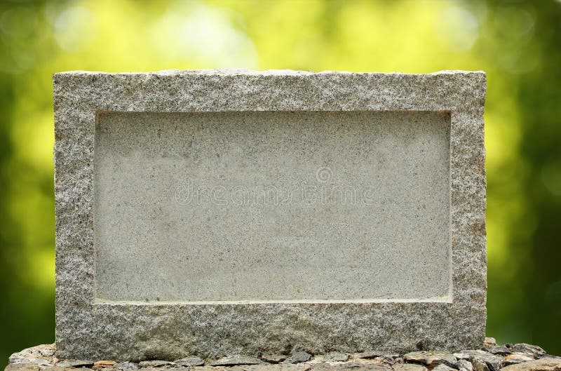 Empty granite signboard with border & frame. The granite is placed in natural outdoor settings showing vibrant green blurred background plants and sunlight effect.