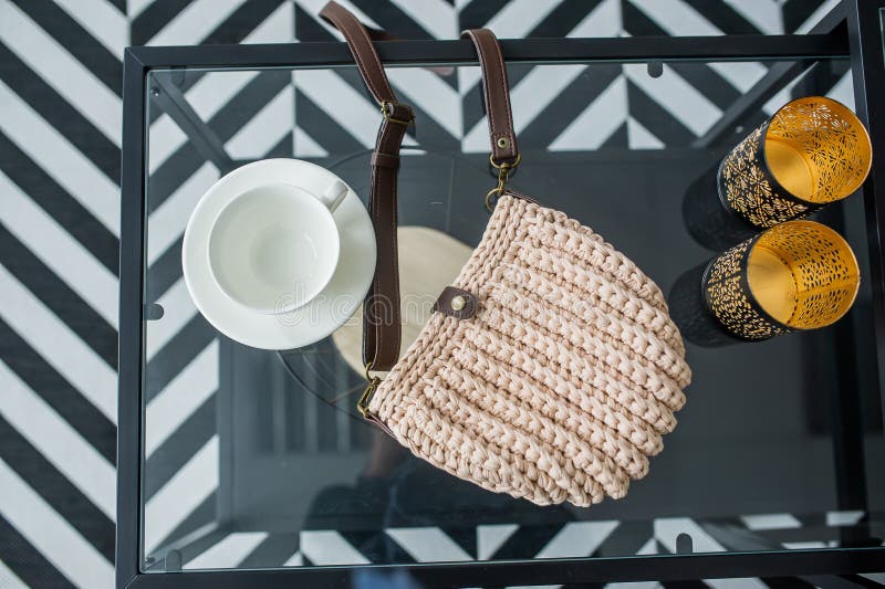 Empty gray knitted purse and empty cups is on glass table. Ad and buy concept. Top view