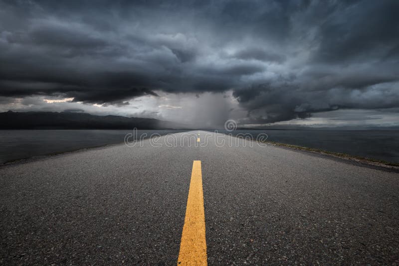 Empty highway leading to the mountains through the rain. royalty free stock photography