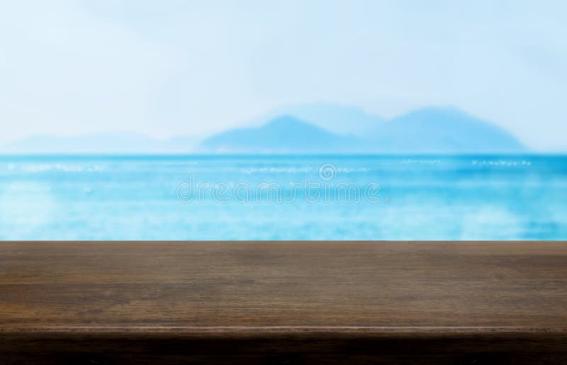 Empty old dark wood table top with blur blue sky and sea bokeh b