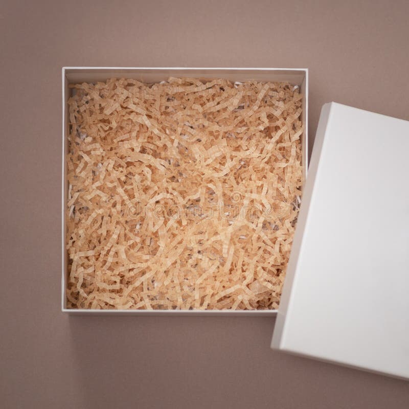 An empty Open Cardboard square box with decorative fillers for your product. Flat lay top view empty space stock image