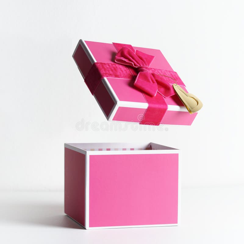 Empty open pink gift box with ribbon and flying lid at white background. Levitation concept present box. Front view with copy stock photos