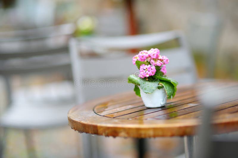 Empty outdoor cafe on beautiful rainy autumn day in Lindau, Germany. Empty chiars and tables under falling rain in autumn.