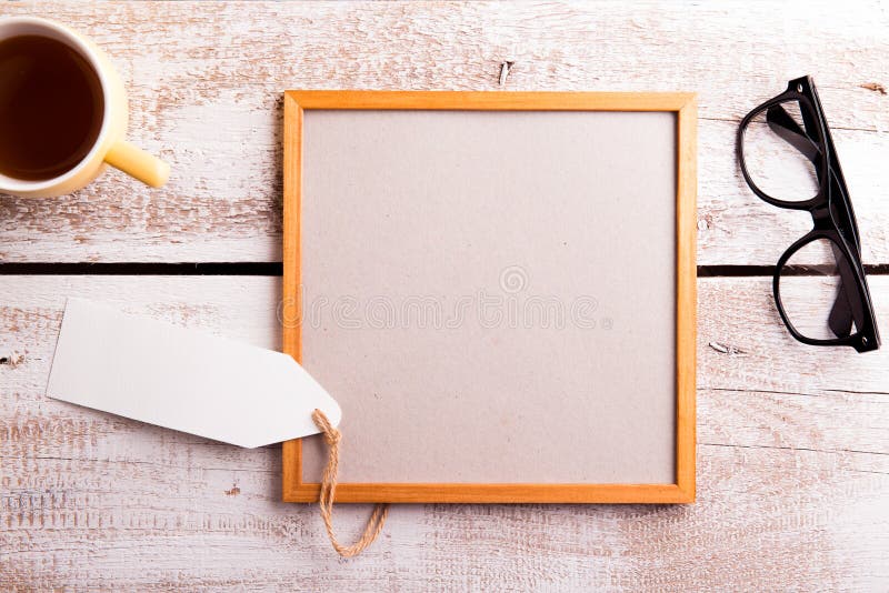 Empty picture frame, eyeglasses and cup of tea