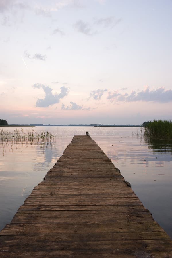 Empty pier by lake at dawn