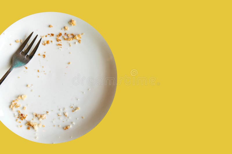 Empty plate with crumbs after eating on a yellow background. The concept of the end of the holiday or celebration