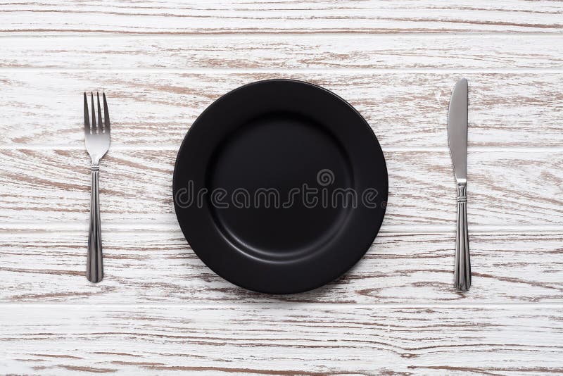 Empty plate fork knife silverware white wooden table background royalty free stock photo