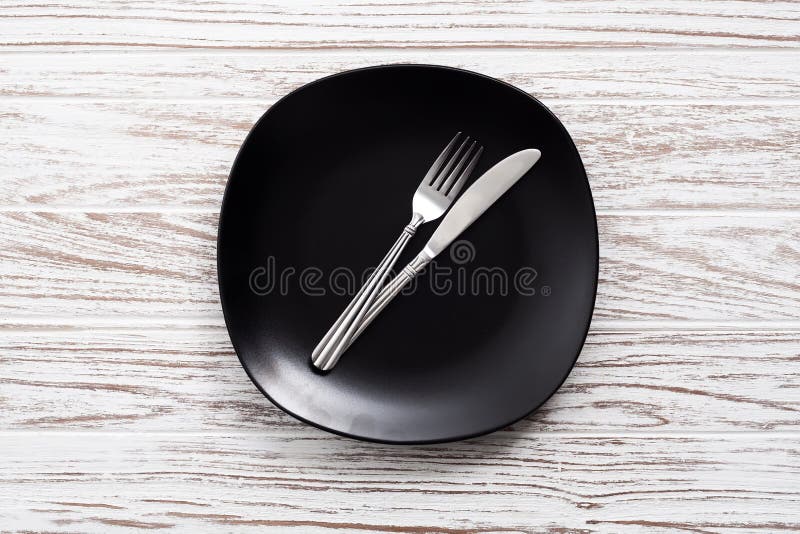 Empty plate fork knife silverware white wooden table background royalty free stock photos